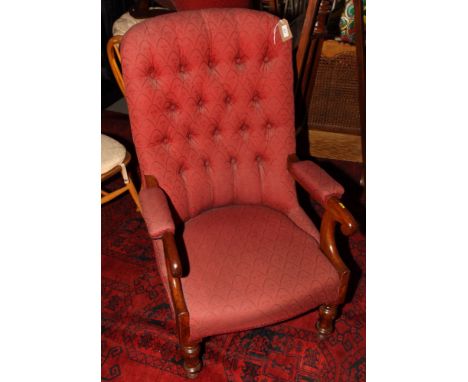 A Victorian mahogany showframe open armchair, button upholstered in a red fabric, on castored supports