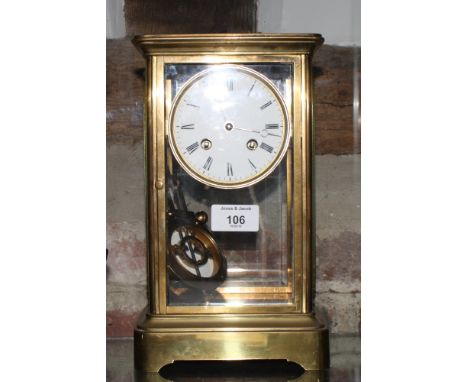 A brass framed mantel clock with bevelled glass sides, white enamel dial, 10 1/2" high