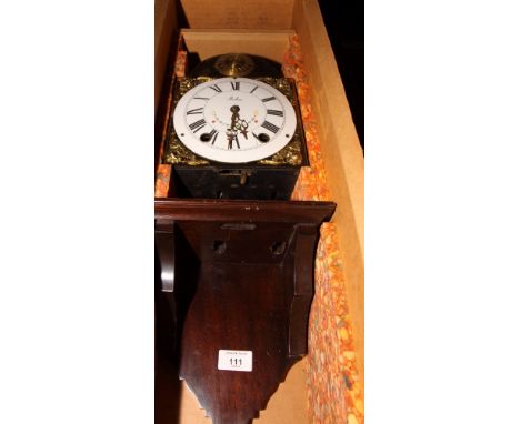 A replica brass Comtoise wall clock with bracket, grid iron pendulum and original packing crate