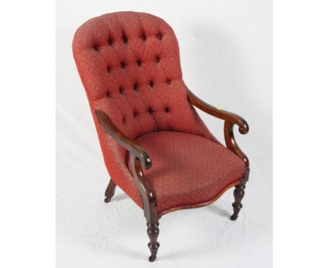 A Victorian mahogany showframe serpentine seat scroll armchair, button upholstered in a red fabric, on turned supports