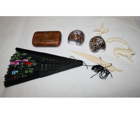 A burr wood rectangular snuff box, two napkin rings made from shells, a black fan and four carved ivory animals