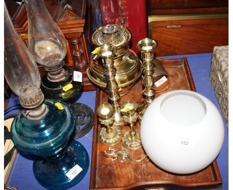 An embossed brass firescreen, two pairs of brass candlesticks, a brass oil lamp, etc