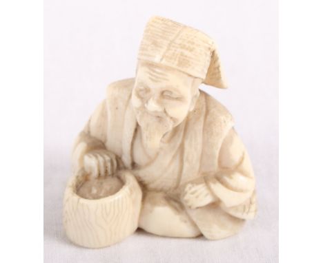 An ivory netsuke of a seated figure with a basket, signed