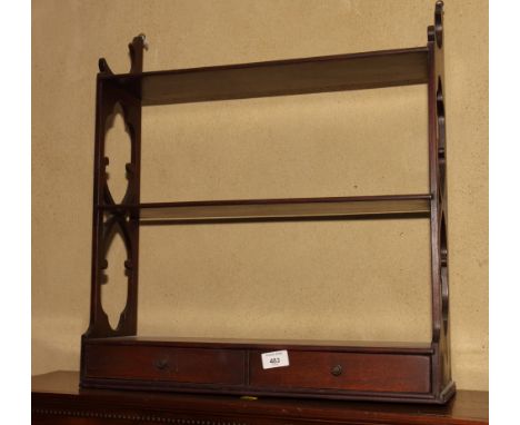 A mahogany wall shelf with fretted sides, fitted two shallow drawers, 21" wide, and another similar wall shelf, 25" wide