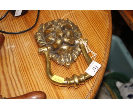 A brass lion mask door knocker