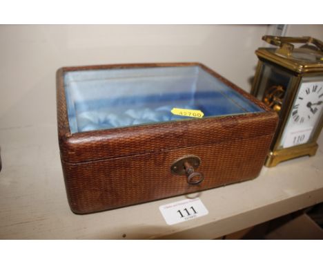 A leather covered trinket case with silk lined button interior