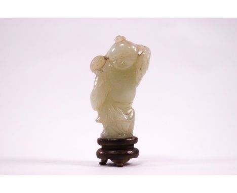 A Chinese jade carving of a robed man, 5.5cm high, on wooden stand
