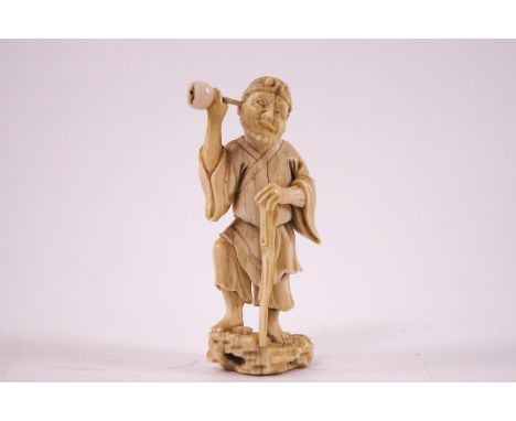 An early 20th century Japanese ivory netsuke, carved as an elderly man with a staff and an ear trumpet, unsigned, 6cm high