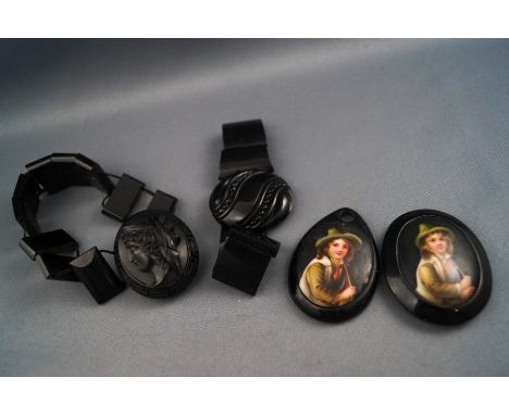 Two jet bracelets and two pendants, set with Berlin portrait plaques. Gross weight: 108.9 grams