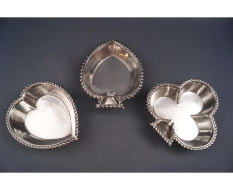 Three silver pin dishes, in the form of playing card suites, club, heart and spade, various dates and makers, 4.3 oz