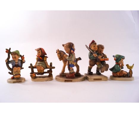 Five Hummel figures, including a  boy with a rocking horse and 'Volunteers'