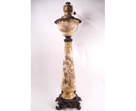 A Victorian porcelain and spelter mounted oil lamp, painted with thistles and gilt highlights, with an 'Ideal Brenner 20" bur