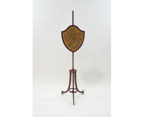 An Edwardian mahogany shield shape fire screen with needlepoint floral panel and height adjustable pulley system, 148cm high