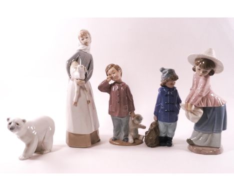 A Lladro figure of a girl holding a lamb, 27cm high, a Lladro polar bear, and three Nao figures