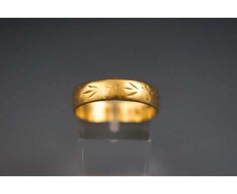 A yellow metal wedding band, 5.7mm with engraved design and personal inscription to inner shank. Hallmarked 18ct gold, Birmin