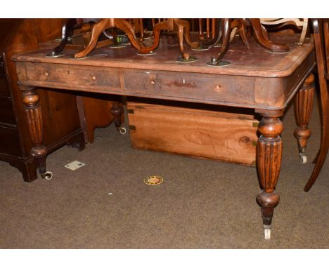 An early 19th century oak writing table with red leather inset, twin drawers, reeded baluster legs and porcelain castors (a.f