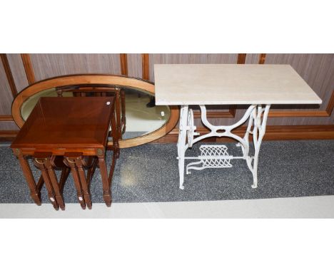 A painted cast-iron treadle sewing machine base, with a later reconstituted marble top, 91cm by 46cm by 72cm high, an oval mi