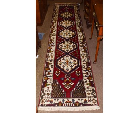 Narrow Kirsehir runner, the field with a column of stepped medallions enclosed by mosque borders, 345cm by 74cm