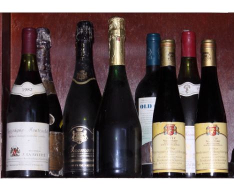 A bottle of Veuve Clicquot 1976 champagne, three other bottles of sparkling wine, a bottle of Chassagne Montrachet 1982, a bo