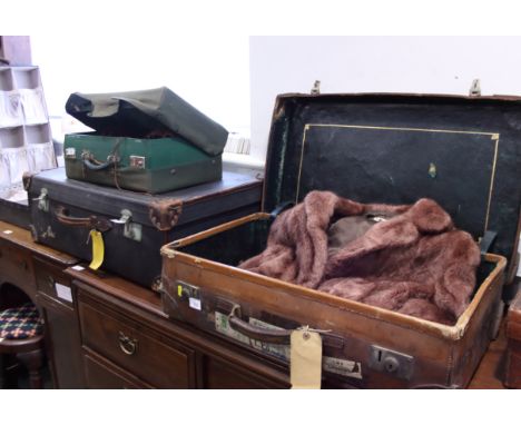 A canvas travelling trunk, a leather suitcase, a shoe case, another case, a fur jacket and two pairs of ice skates