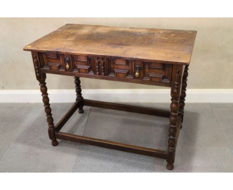 An antique oak side table, fitted one drawer with field panelled front, on bobbin turned and stretchered supports, 35 1/2" wi