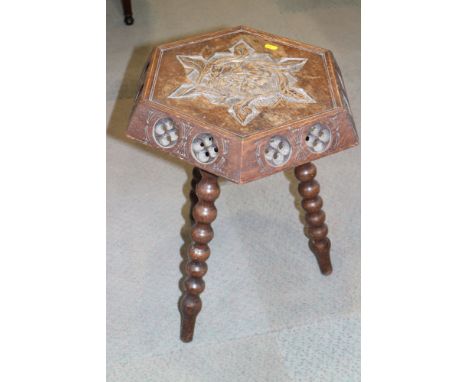 A late Victorian carved oak hexagonal top occasional table, on bobbin turned supports, 20" wide