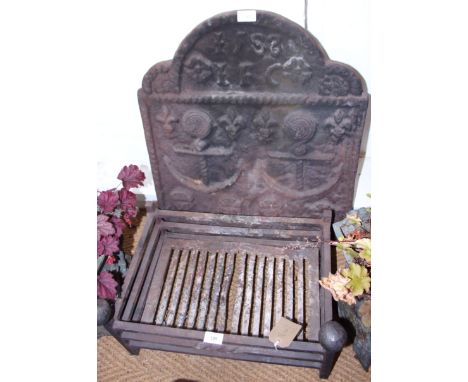 A wrought iron fireguard and a cast-iron fireback