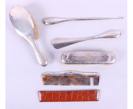 A silver backed hairbrush, a clothes brush, a shoehorn, a button hook and a comb with leather slip case