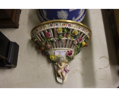 A continental porcelain floral encrusted and cherub mounted wall bracket 