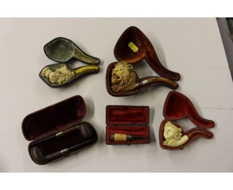 A large Meerschaum pipe in the form of a lions head; together with two other pipes; a cased pair of wooden pipes with silver 