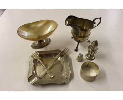 A box of mixed silver to include a cream jug, Chester 1899; an ash tray with engine turned decoration; a serviette ring; a pe