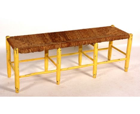 A vintage painted stool, of long form with woven rush top, 45cm high x 129cm long