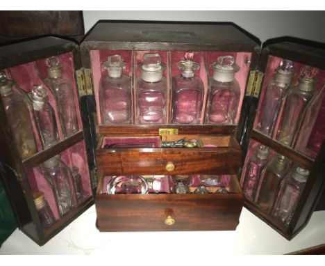 A Victorian mahogany domestic medicine chest, flush handle above two hinged doors enclosing various jars and two small drawer