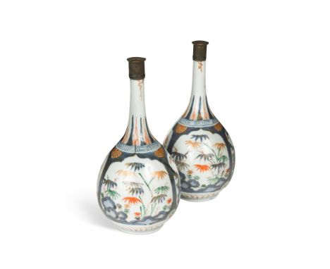 A pair of Japanese Arita porcelain bottle vases, Edo period, early 18th century, painted in underglaze blue with pine, prunus