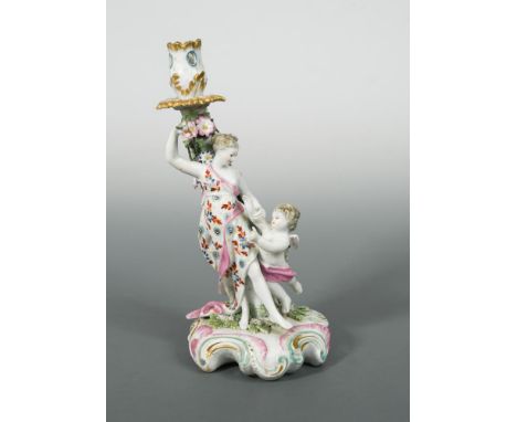 A Derby Patch Mark figural candlestick of 'Venus with Cupid', circa 1770, with foliate sconce and floral encrusted stem, on a