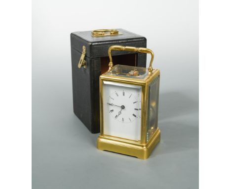 A French 19th century gilt brass carriage clock, with white enamel dial and Roman numerals, bell striking movement, in a plai