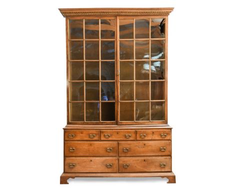 A George II walnut and parcel gilt large bookcase, the upper part with two glazed panelled doors surmounted by a dentilled, e