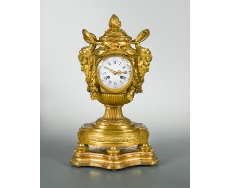 A French late 19th century neo classical ormolu mantel clock, the urn shape case with bud finial above a pair of serpent entw