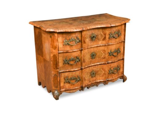 An early 18th century German walnut commode, of en arbalete outline and inlaid with the crest of a Count, on shaped feet 76 x