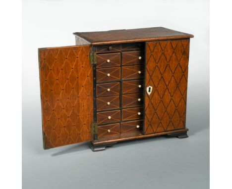 A 19th century marquetry inlaid oak table cabinet, the pair of doors opening to reveal a series of drawers within, all with l