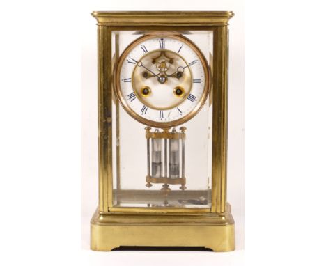 A late 19th/early 20th century brass corniche and four glass mantle clock, the white enamelled dial with twin winding holes a