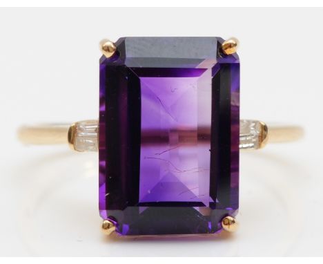 A 9ct gold emerald cut amethyst cocktail ring, with baguette cut diamonds to the shoulders, R-S, 3.5gm. 