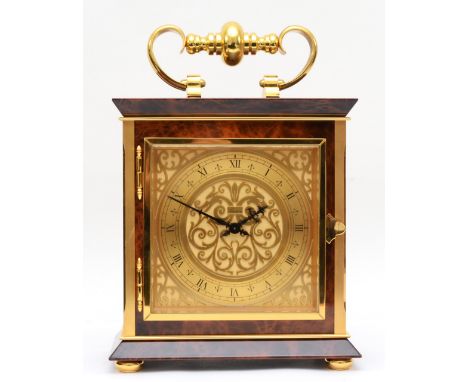 Luxor, a contemporary brass mantle clock, the brass dial with black Roman numerals and scroll decoration, with carrying handl