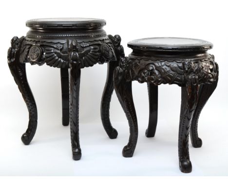 Two 20th century carved Chinese hardwood stands, the tops each incised with Greek Key pattern, with heavily carved freize and