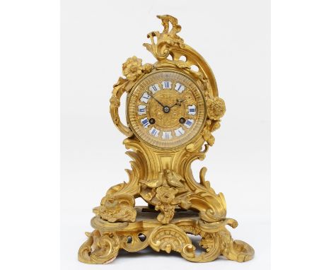 A late 19th century, probably French gilt brass mantle clock, the gilt dial with applied enamel Roman numerals, cast with flo