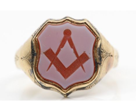 Masonic interest; A Victorian gold Masonic signet ring with carved square and compass in sardonyx shield, with chase floral d