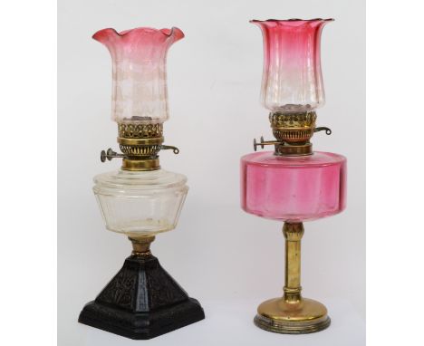A 19th/early 20th century brass and glass oil lamp, with clear and cranberry glass shade etched with scroll decoration and cr