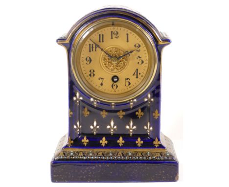 An early 20th century cobalt blue cased dome topped porcelain cased mantle clock, decorated with gilt painted and enamel fleu