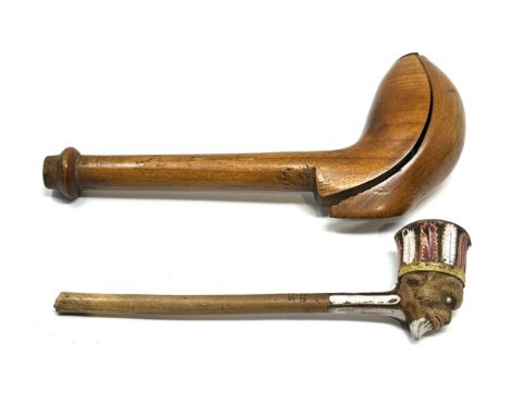 An 18thC carved fruit wood pipe case opening to reveal a clay pipe having glazed indian head 