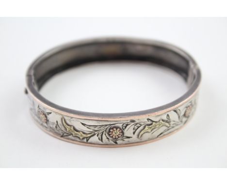 A decorative Victorian silver bangle with gold floral detailing (16g) 
